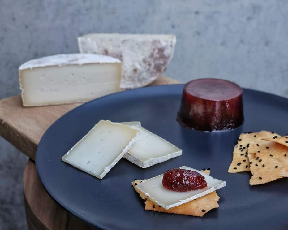 Slices of Bellarine Tomme semi-hard goat cheese with quince paste and crackers