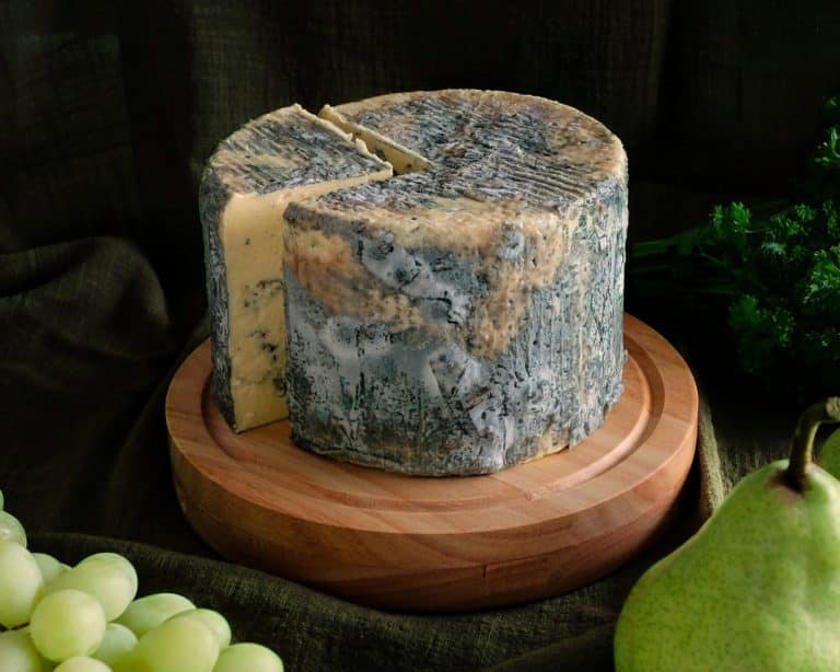 Wheel of Cashel Blue cheese with a wedge cut out