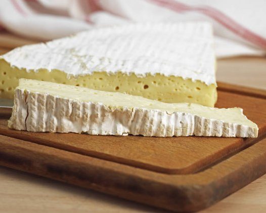 Wedge of Brie with a slice cut off lengthwise