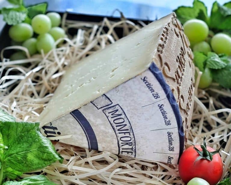 Wedge of Monforte on a bed of straw and grapes
