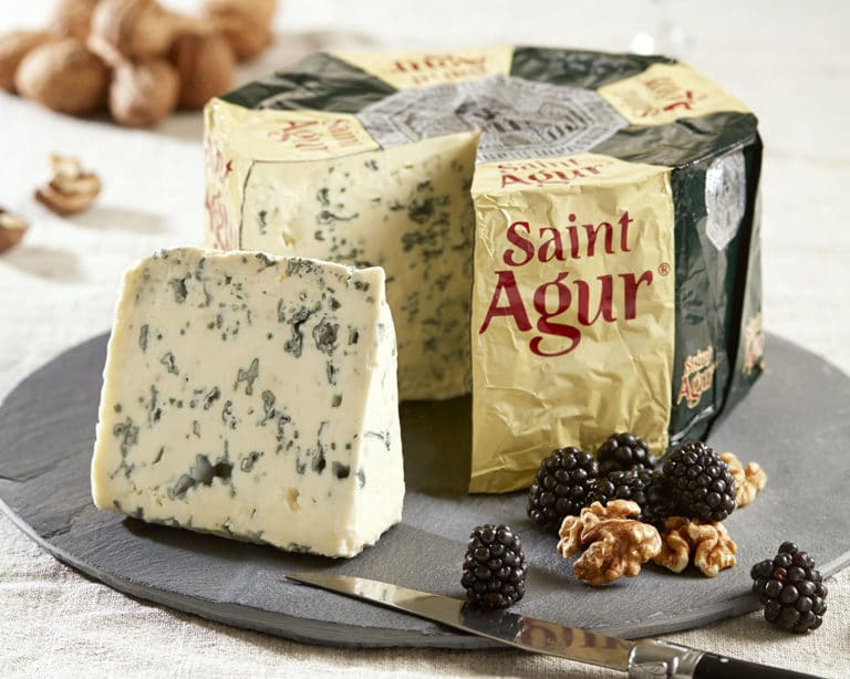 Wheel of Saint Agur blue cheese with a wedge cut out