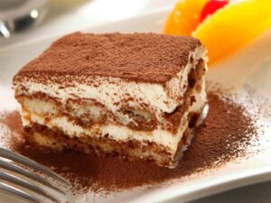 Feature Tiramisu sprinkled with cocoa dust on a white plate