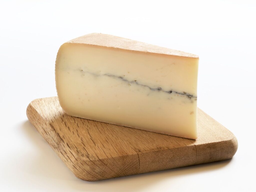 Wedge of Morbier semi-hard cheese with a line of ash through it
