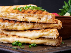 Feature Grilled Cheese Sandwich sliced in half diagonally and oozing melted cheese